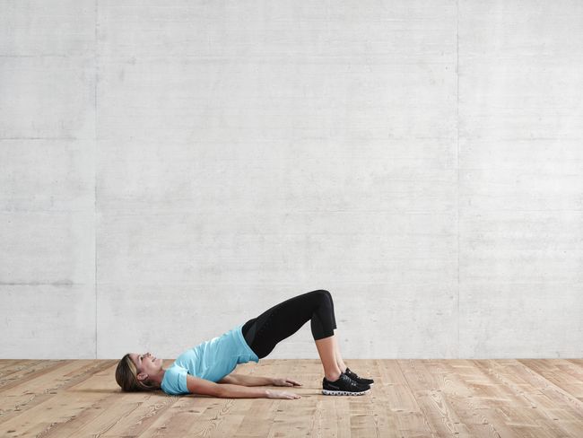 une femme en tenue de sport fait un demi-pont.