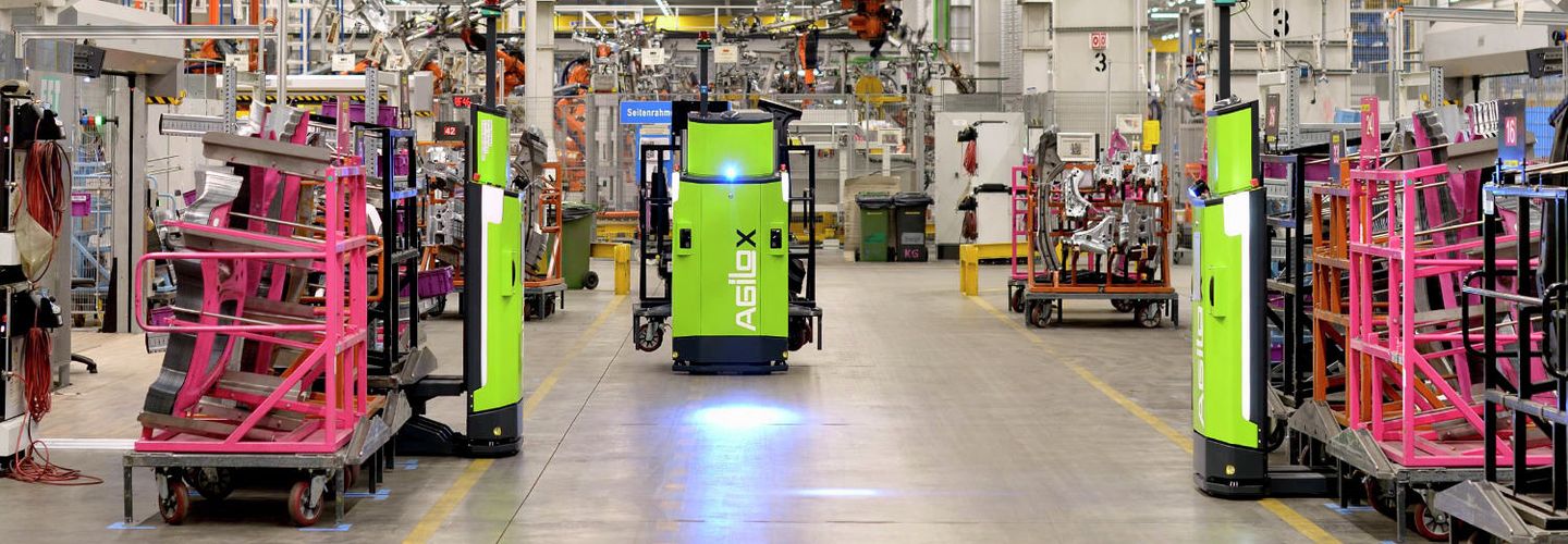 Ein Fahrzeug durchquert eine Halle. Ein starker Scheinwerfer zeichnet einen blauen Lichtstrahl auf den Boden. 