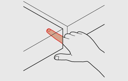 Un travailleur met son doigt dans une ouverture entre deux plans verticaux. L’écartement minimal est ici de 25 mm. Le doigt est coloré en rouge.