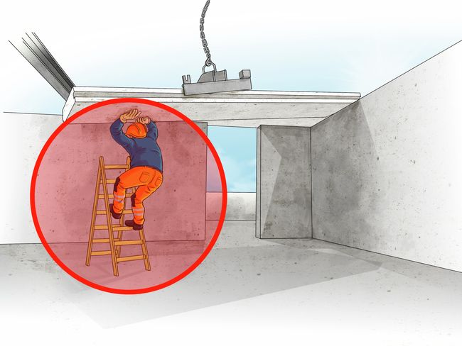 Ein Bauarbeiter steht auf einer Bockleiter direkt unterhalb eines frei schwebenden Betonelements, als sich dieses aus dem Greifer löst und auf ihn herabstürzt.