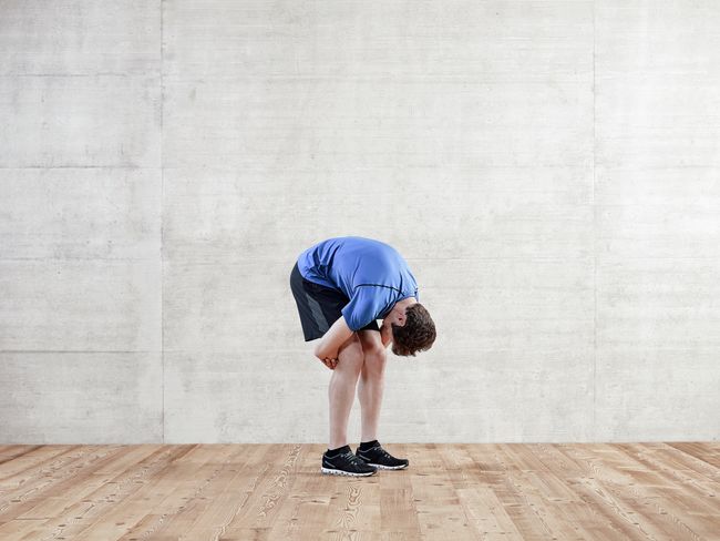 Exercice d’étirement de la musculature dorsale par inclinaison et saisie des creux des genoux.