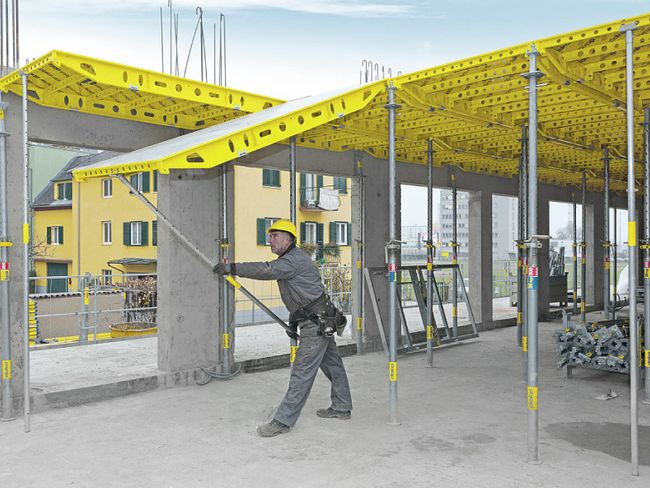 Un sistema di casseratura per solai a pannelli viene fissato da un addetto al cantiere.