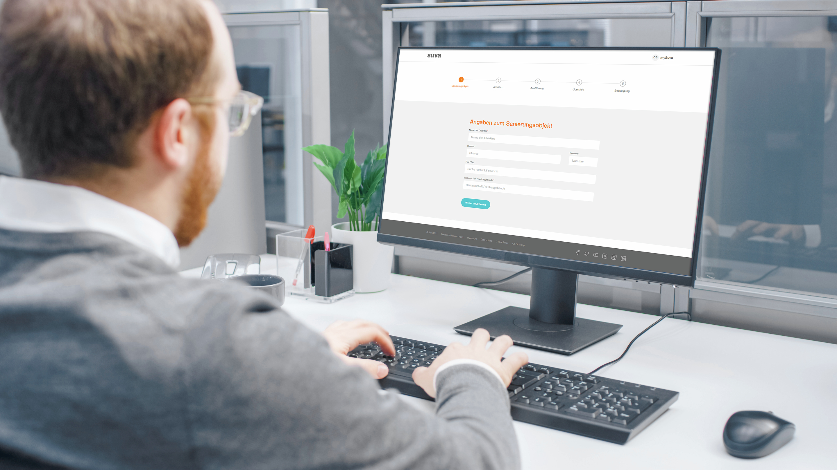 Mann sitzt vor dem Computer und nutzt die Anwendung «Asbestsanierung».
