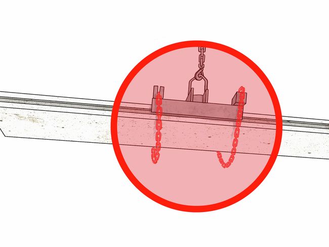 Un elemento in calcestruzzo pende in aria da una tenaglia. Le catene di sicurezza mancanti sono evidenziate in rosso.