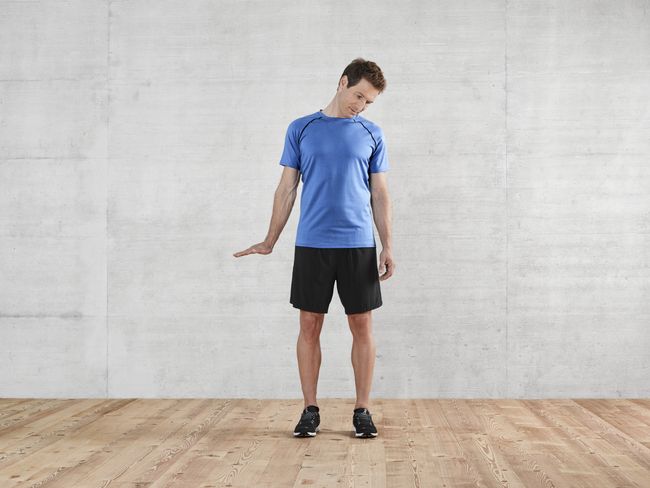 un homme en tenue de sport s’étire la nuque.