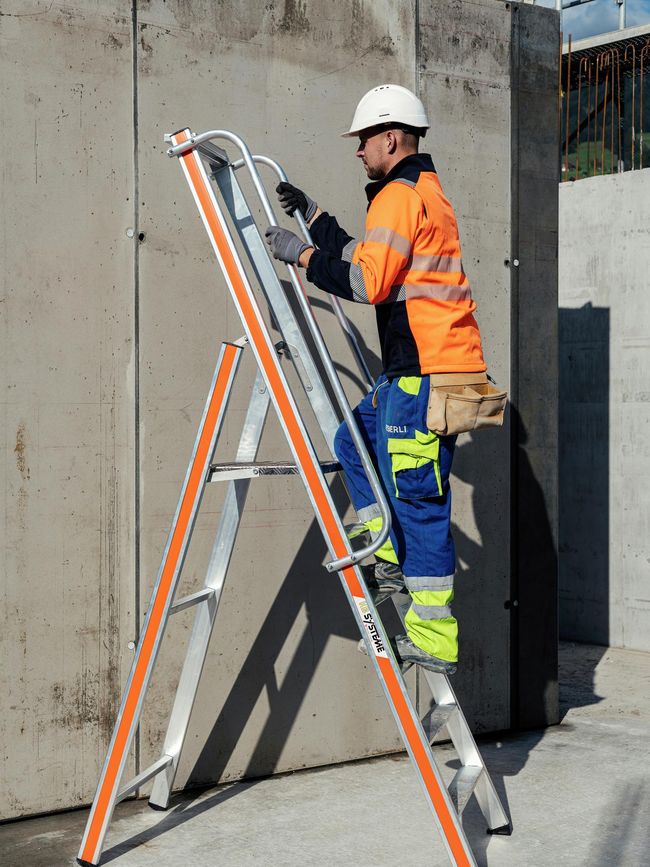Un operaio sale su una scala leggera con piattaforma.