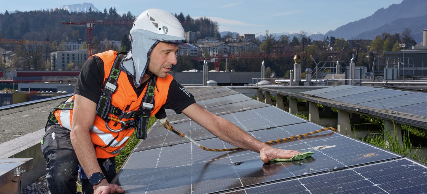 Solaranlage auf Flachdach mit Geländer und Brüstung als Massnahmen zur Absturzsicherung für Instandhaltungsarbeiten.