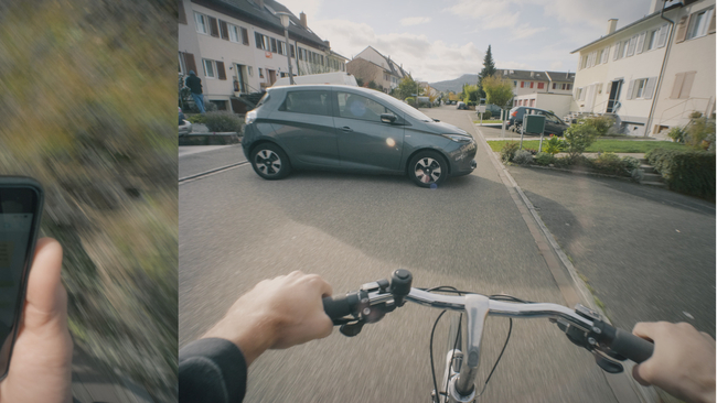 Il video mostra due volte, parallelamente, lo stesso ciclista: una volta con il cellulare in mano, una volta senza.