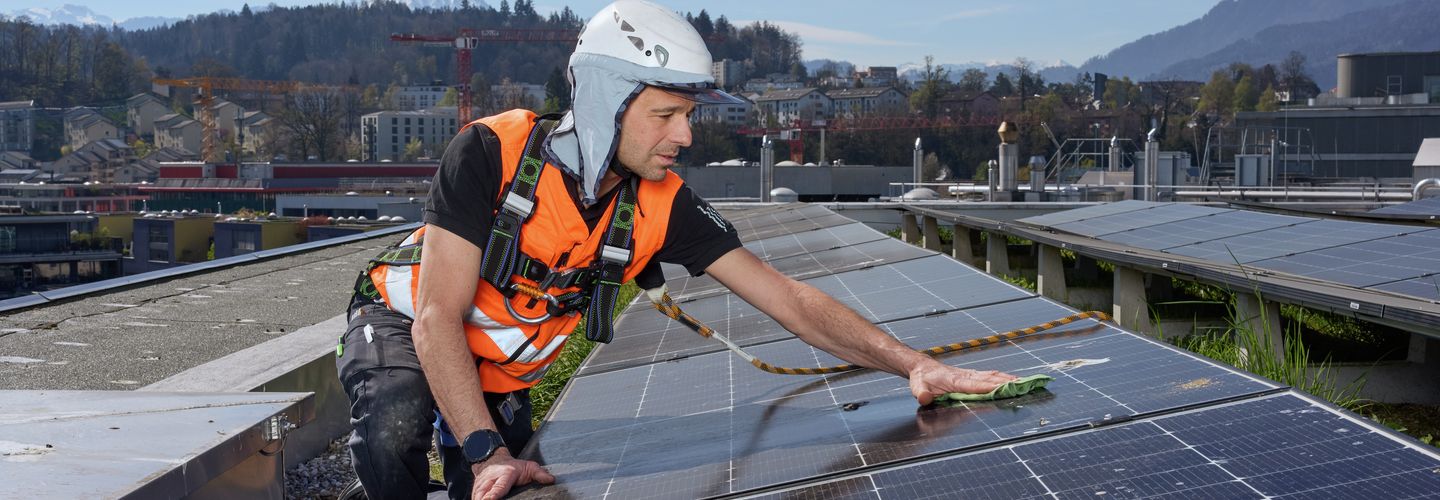 Solaranlage auf Flachdach mit Geländer und Brüstung als Massnahmen zur Absturzsicherung für Instandhaltungsarbeiten.