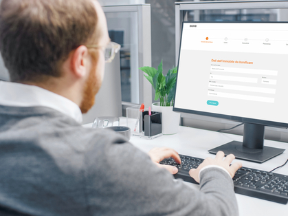 Uomo seduto davanti al computer che utilizza l'applicazione «Rimozione amianto».