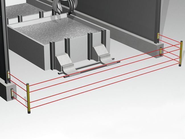 Une barrière photoélectrique dotée de quatre rayons lumineux est placée sur le sol devant une installation.