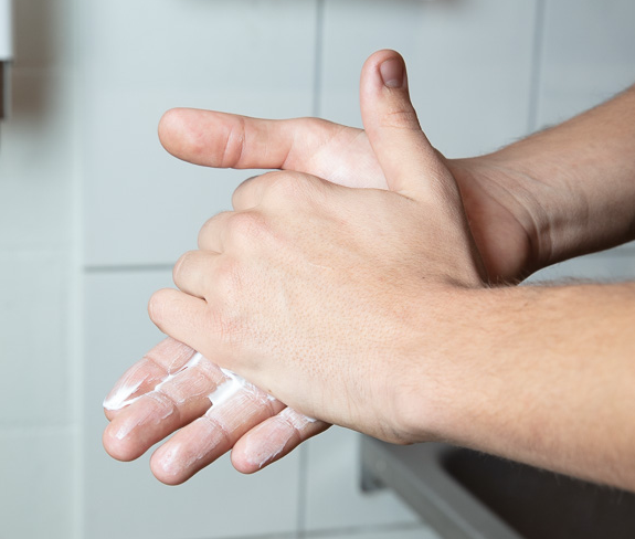 Nahaufnahme: Zwei Hände, die Hautpflegecreme einreiben.
