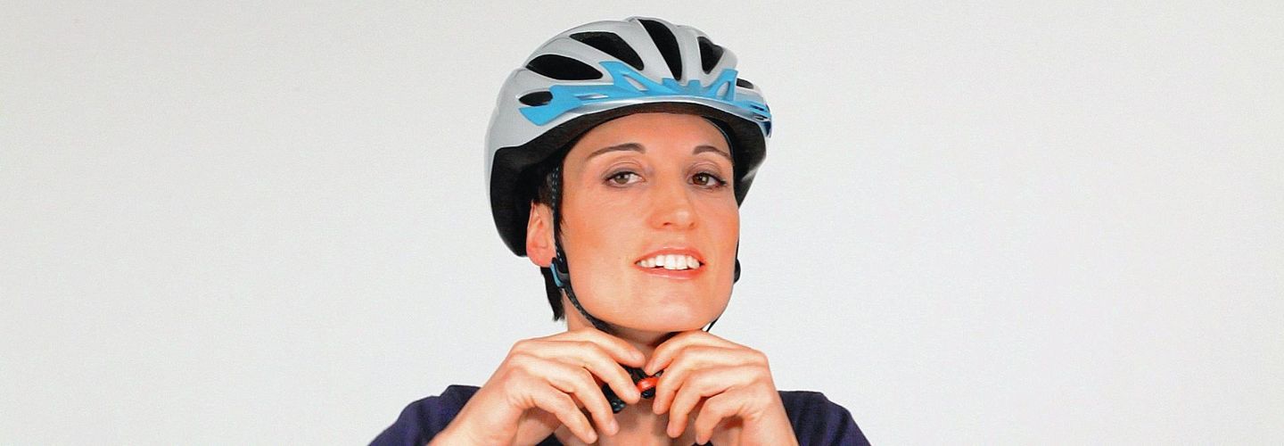La copertina del video mostra una donna che indossa un casco da bici e lo sta regolando.
