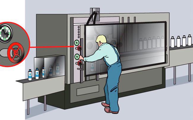 Production en cours, un opérateur procède à des ajustements sur la machine. Pour ce faire, il peut utiliser les organes de réglage situés à l’extérieur du capot de protection.