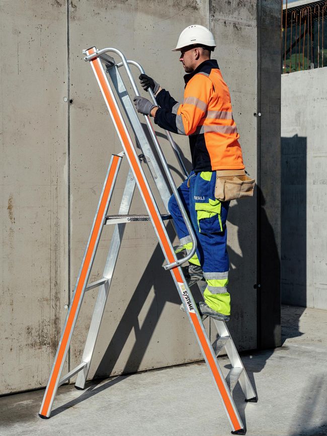 Un ouvrier du bâtiment monte sur une échelle à plateforme légère.
